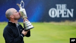 American Brian Harman poses for the media as he holds the Claret Jug trophy after winning the British Open Golf Championships at the Royal Liverpool Golf Club in Hoylake, England, July 23, 2023.