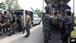 Members of the Philippine National Police Special Action Forces load bodies of police commandos into vehicles in Maguindanao, Philippines, Monday, Jan. 26, 2015.