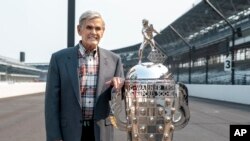 FILE - Four-time winner of the Indianapolis 500, Al Unser, poses with the Borg-Warner Trophy at the Indianapolis Motor Speedway in Indianapolis, July 20, 2021.