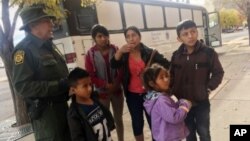 Archivo - Una familia de migrantes centroamericanos aguarda frente a un refugio en El Paso, Texas, el 29 de noviembre de 2018.