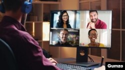 A user watches a video conference in this promotional image from Gumzo.
