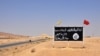 FILE - This photo taken Aug. 13, 2017, shows an Islamic State group sign in the central Syrian town of al-Sukhnah.