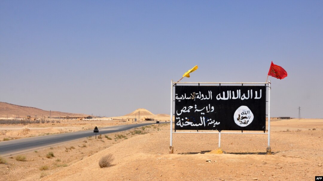FILE - A general view taken on Aug. 13, 2017, shows an Islamic State (IS) group sign in the central Syrian town of Al-Sukhnah. Pro-government fighters cleared the area after taking control of the county's large desert area called the Badiya.