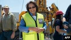 Le maire de Cap, Patricia de Lille, au centre, parle aux médias sur un site où le conseil municipal a ordonné de forer dans l'aquifère, à Mitchells Plain, à environ 25 km du centre-ville le 11 janvier 2018 au Cap (AFP PHOTO / RODGER BOSCH).