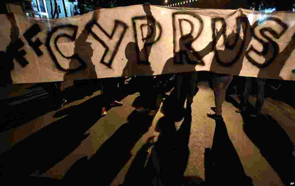 24일 키프로스 구제금융 협상이 계속되는 가운데, 의회 앞에 현수막을 설치하고 구제금융에 반대하는 시위대. 