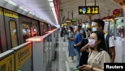 People wearing protective face masks wait for the metro, during the coronavirus disease (COVID-19) pandemic, in Taipei, Taiwan, May 11, 2021. REUTERS/Ann Wang