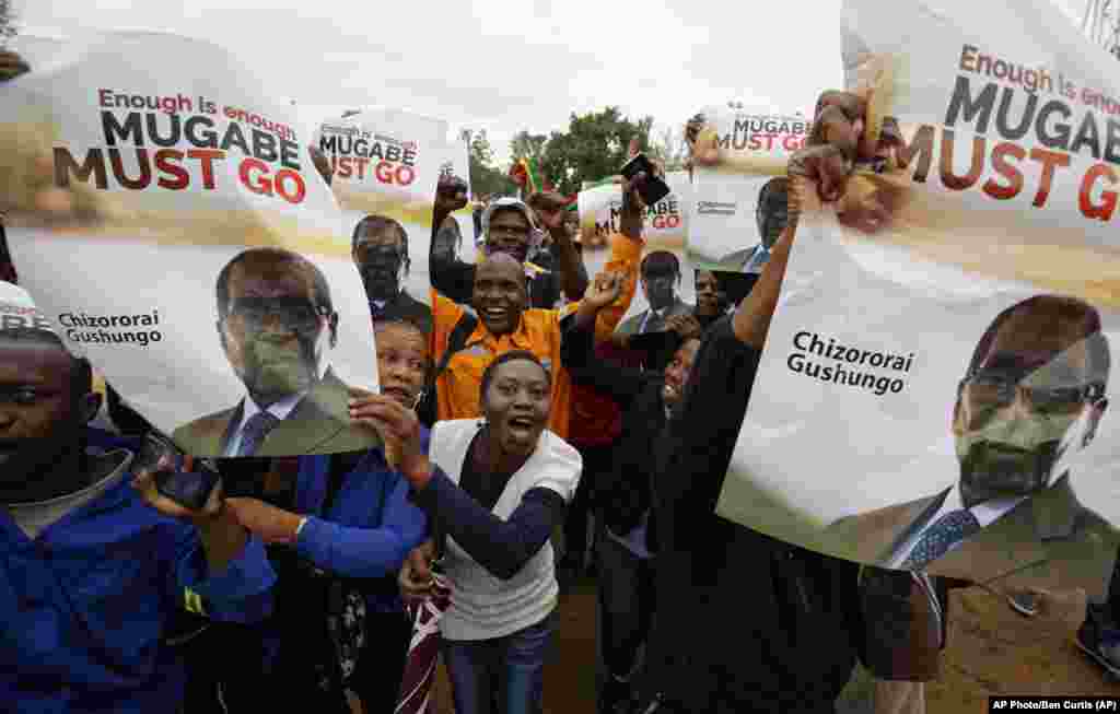 Les manifestants brandissent des affiches demandant au président Mugabe de démissionner à Harare, Zimbabwe, 18 novembre 2017.