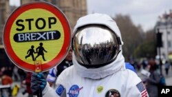 Un manifestante vestido de astronauta muestra un cartel con el lema "Paren el Brexit" durante una manifestación contra la salida del Reino Unido de la Unión Europea, en Londres, el 23 de marzo de 2019.