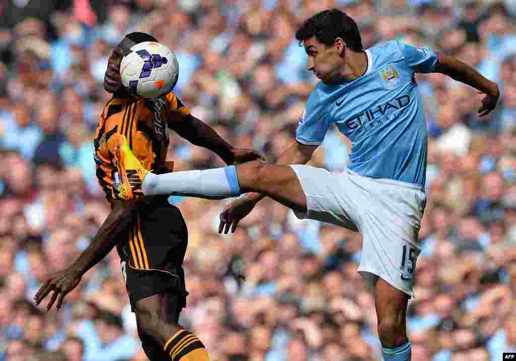 Gelandang Manchester City dari Spanyol, Jesus Navas, berebut bola di udara dengan bek Hull City dari Honduras, Maynor Figueroa (kiri) dalam pertandingan Liga Premier Inggris antara Manchester City dan Hull City di Stadion Etihad di Manchester. Manchetser City memenangkan pertandingan, 2-0.