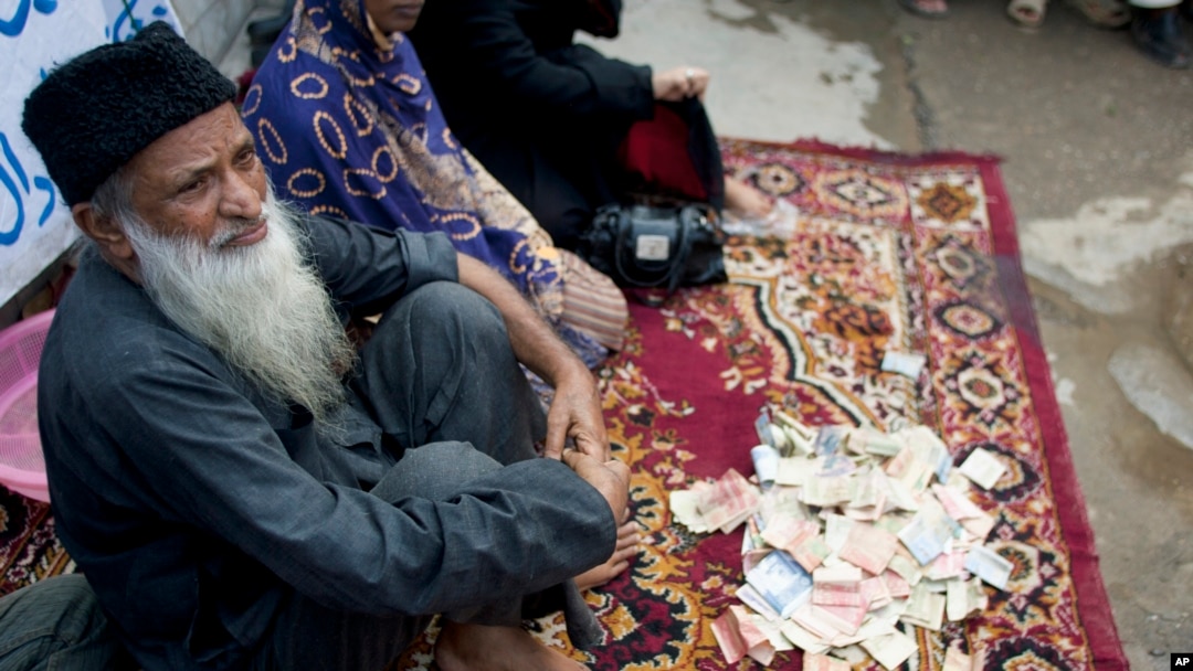 FILE - Pakistan's humanitarian leader Abdul Sattar Edhi collects donations at a roadside spot in Peshawar, Pakistan, Aug. 2, 2010.