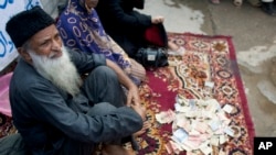 FILE - Pakistan's humanitarian leader Abdul Sattar Edhi collects donations at a roadside spot in Peshawar, Pakistan, Aug. 2, 2010.