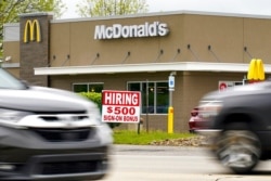 FILE - A hiring sign offers a $500 bonus outside a McDonalds restaurant, in Cranberry Township, Butler County, Pa., May 5, 2021.
