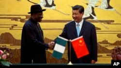 Presiden China Xi Jinping (kanan) berjabat tangan dengan Presiden Nigeria, Goodluck Jonathan di Beijing hari Rabu (10/7). 