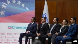 FILE - Chevron President in Venezuela, Javier La Rosa, left, attends a signing agreement ceremony between Venezuela and the California-based Chevron, in Caracas, Venezuela, Dec. 2, 2022.