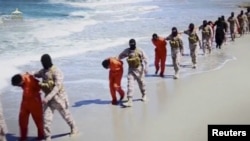 Militan dari kelompok ISIS menggiring orang-orang yang diduga sebagai warga Kristen Ethiopia di pinggir pantai di Wilayat Barqa, dalam foto yang diambil dari video yang ditampilkan di media sosial, bulan lalu. 