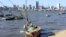 FILE - A fisherman cleans his boat beneath Maputo’s skyline in Mozambique on Aug. 15, 2015. A member of the Renamo party was killed Oct. 8, 2016, on a Maputo beach.