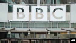 ARCHIVO - El cartel de la BBC se ve fuera de la entrada de la sede de la organización de medios financiada con fondos públicos, el 19 de julio de 2017, en Londres.