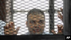 FILE - In this Wednesday, Dec. 4, 2013 file photo, Mohammed Badr, a cameraman for Al-Jazeera Mubasher Misr, appears at a court in Cairo, Egypt. 