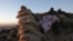 FILE - A Kurdish fighter, known as a Peshmerga, lies underneath a blanket, overlooking the town of Sinjar, Iraq, Nov. 13, 2015.