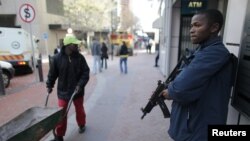 A private security guard stands outside of an ATM machine in downtown Cape Town, South Africa, June 9, 2010.