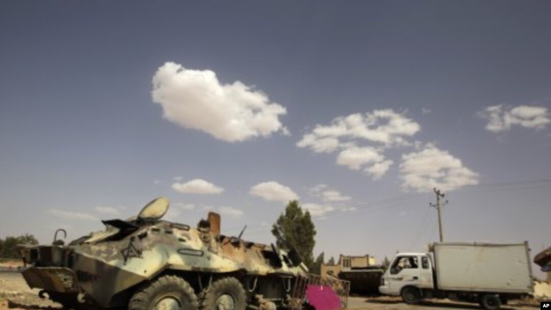 Armoured vehicles belonging to Muammar Gaddafi's troops, which were destroyed by an earlier air strike, are left near the village of Al-Qawalish July 18, 2011