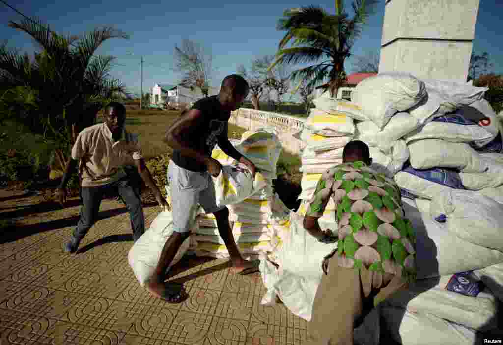 Workers offload food aid from a South African National Defense Force helicopter in the aftermath of Cyclone Idai in Buzi, near Beira, Mozambique, March 25, 2019. 