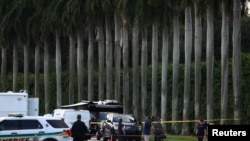 Sejumlah petugas penegak hukum sedang bekerja di tempat kejadian penembakan di luar klub golf milik capres dari Partai Republik AS, Donald Trump, di West Palm Beach, Florida, Minggu, 15 September 2024. (Foto: Marco Bello/Reuters)