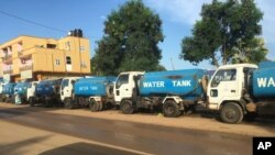 FILE - Trucks wait at a fuel station in South Sudan's capital of Juba, Oct. 1, 2017.