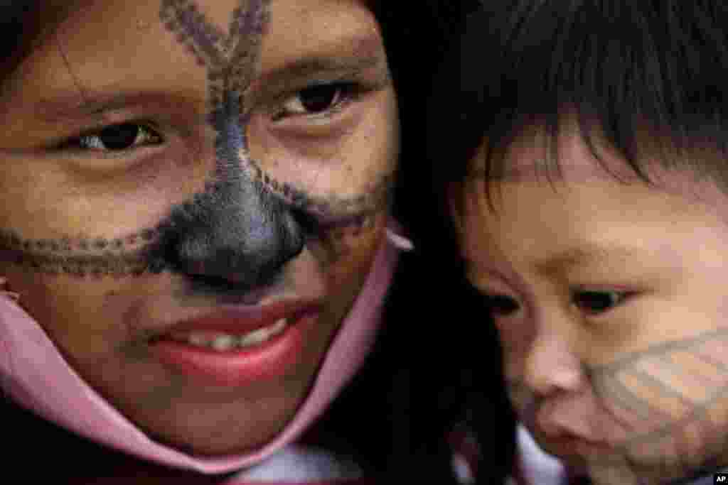 A Munduruku Indigenous woman and child from Alto Tapajos in the Brazilian state of Para attend a show of support for a government decree legalizing mining on Indigenous land outside the Supreme Court in Brasilia.