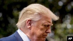 President Donald Trump pauses while speaking with members of the media before boarding Marine One on the South Lawn of the White House in Washington, Aug. 6, 2020.