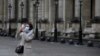 Un turista cubierta con una máscara de sanidad se hace una selfie frente al museo del Louvre el viernes 28 de febrero de 2020 en París. El museo cerró sus puertas el domingo 1 de marzo, por temores al coronavirus.