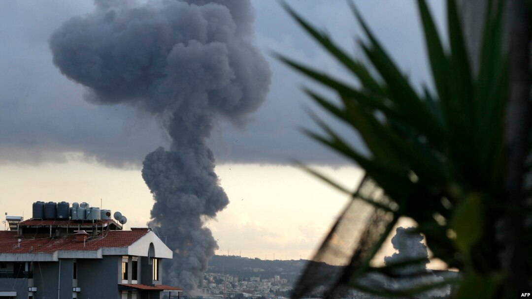 Asap mengepul menyusul dua serangan udara Israel (kiri dan kanan) di Kota Ghaziyeh di Lebanon selatan pada 19 Februari 2024. (Foto: AFP)