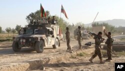 FILE - Afghan national army soldiers stand near the body of a Taliban fighter killed in Ghazni province, eastern Afghanistan, Sept. 14, 2015. The Afghan intelligence agency, the National Directorate of Security (NDS), says, Dec. 5, 2017, joint U.S.-Afghanistan operation have killed several high-profile leaders of al-Qaida, along with 80 other members of the terrorist network and Taliban fighters.