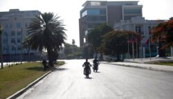 Sejumlah pengendara motor melintas di jalanan yang sepi dekat Istana Nasional di Port-au-Prince, Haiti, 7 Juli 2021.