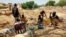 FILE - Informal gold miners are seen taking a break from work under the midday sun at an artisanal mining site near Dano, southern Burkina Faso, May 5, 2020. 