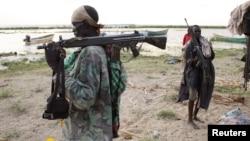 Des habitants de Turkana porte une mitraillette sur l'épaule sur la berge au lac Turkana, près deTodonyang au nord Kenya, le 25 novembre 2014.