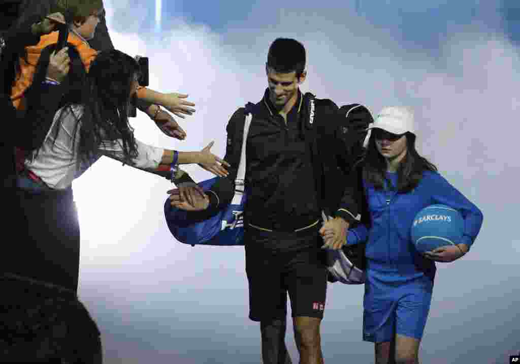 Novak Đoković stiže na teren O2 Arene pred početak polufinalnog duela protiv Huana Martina Del Potra (AP Photo/Sang Tan)