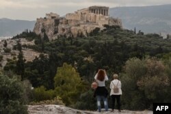 People visit the Pnyx Hill in Athens overlooking the ancient Acropolis on May 29, 2020 as Greece eases lockdown measures taken to curb the spread of COVID-19.
