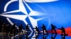 Коллаж, где фигурки игрушечных солдат на фоне логотипа НАТО и цветов российского флага вступают в бой друг с другом (REUTERS/Dado Ruvic/Illustration/File Photo)