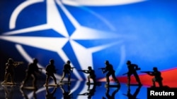 Коллаж, где фигурки игрушечных солдат на фоне логотипа НАТО и цветов российского флага вступают в бой друг с другом (REUTERS/Dado Ruvic/Illustration/File Photo)