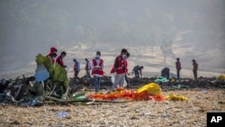 FILE - Rescuers work at the scene of an Ethiopian Airlines Boeing MAX crash on March 11, 2019, near Bishoftu, or Debre Zeit, Ethiopia.