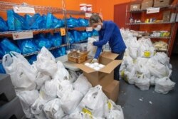 A volunteer prepares bags with groceries for delivery at The Campaign Against Hunger food pantry, Thursday, April 16, 2020, in the Bedford-Stuyvesant neighborhood of the Brooklyn borough of New York.