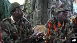 FILE—In this November 12, 2006 photo the leader of the Lord's Resistance Army, Joseph Kony, left, and his deputy Vincent Otti sit inside a tent at Ri-Kwamba in Southern Sudan.