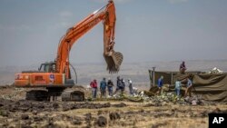 Para penyelidik bekerja di lokasi jatuhnya pesawat Boeing 737 Max 8 milik Ethiopian Airlines dekat kota Bishoftu, Ethiopia (15/3). 