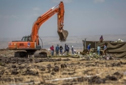 FILE - Investigators conducting recovery work at the scene where the Ethiopian Airlines Boeing 737 Max 8 crashed shortly after takeoff on Sunday killing all 157 on board, near Bishoftu, south-east of Addis Ababa, Ethiopia, March 15, 2019.