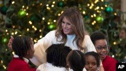 La primera dama de EE.UU., Melania Trump, saluda a niños de una escuela que invitó para ver los adornos navideños de la Casa Blanca. La señora Trump eligió una decoración tradicional para su primera Navidad en la Casa Blanca.