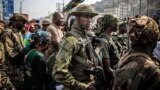 (FILE) Members of the M23 movement monitor the area while guarding senior members of the group at the Place de l'Independance in Bukavu on February 20, 2025. 