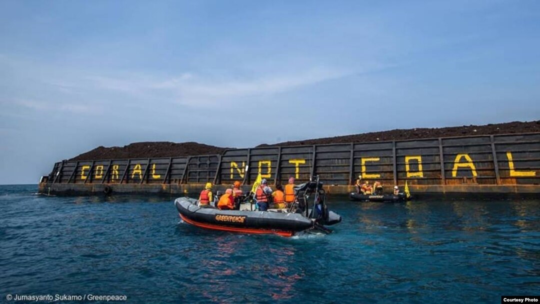 Aktivis Greenpeace menulis Coral not Coal di lambung tongkang batubara di Karimunjawa. (Foto: Greenpeace Indonesia)