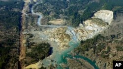 The massive mudslide that killed at least eight people Saturday and left dozens missing is shown in this aerial photo, March 24, 2014, near Arlington, Washington. 