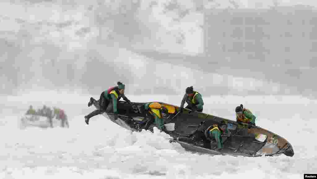 Team Bota Bota competes during the Quebec Winter Carnival ice canoe race on the St. Lawrence River in Quebec City, Canada, Feb. 8, 2015.